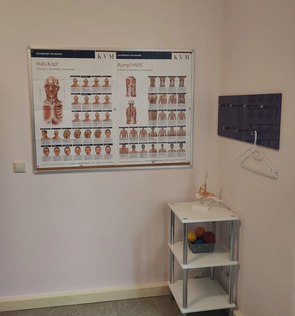 Behandlungskabine mit Abstelltisch und anatomischen Anschaungsmaterial.